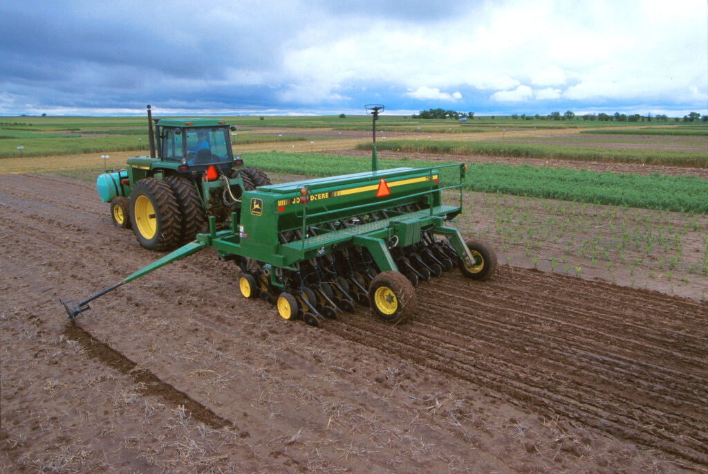 A farmer uses his John Deere tractor to plant foxtail millet. Photo by Scott Bauer, USDA Agricultural Research Service.